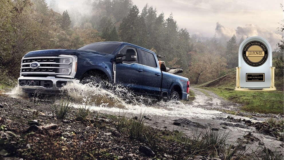Blue 2025 Ford Super Duty splashing through a creek with JD Power award displayed for quality.