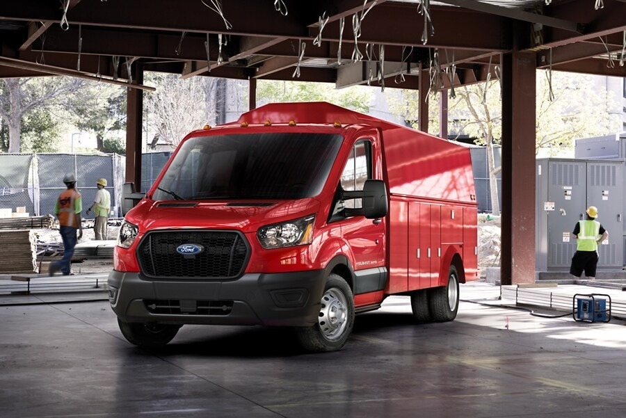 Red Ford Transit upfitted for commercial use parked inside an active construction site.